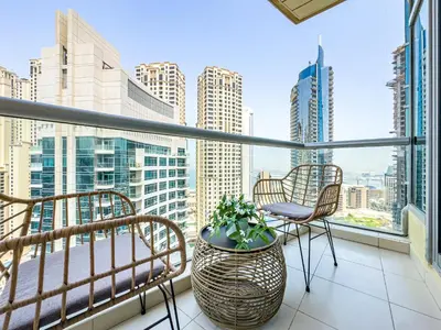 a balcony with chairs and a view of the city at Luxury Stay - Private Jacuzzi - Infinity Pool - Marina & Sea Views - High Floor - Upgraded - Designer - Squash in Dubai