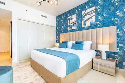 a bedroom with a large bed with blue walls at Luxury Stay - Private Jacuzzi - Infinity Pool - Marina & Sea Views - High Floor - Upgraded - Designer - Squash in Dubai