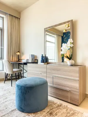 a living room with a large mirror and a blue ottoman at Luxury Stay - Private Jacuzzi - Infinity Pool - Marina & Sea Views - High Floor - Upgraded - Designer - Squash in Dubai
