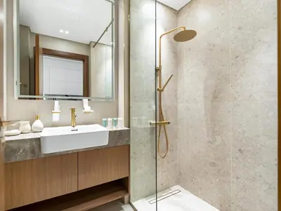 a bathroom with a glass shower and a sink at Modern Studio Private Jacuzzi Canal View in Dubai
