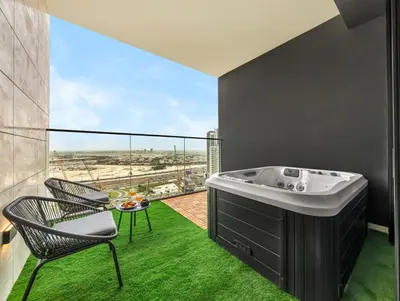 a bathroom with a tub and a table and chairs at Modern Studio Private Jacuzzi Canal View in Dubai