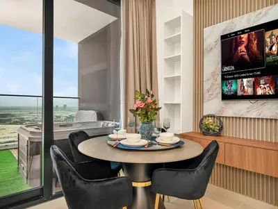 a dining room with a table and chairs and a television at Modern Studio Private Jacuzzi Canal View in Dubai