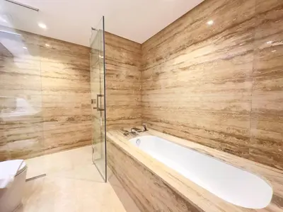 a bathroom with a tub and a glass shower at Modern & Stylish 2BR Apartment in Dubai