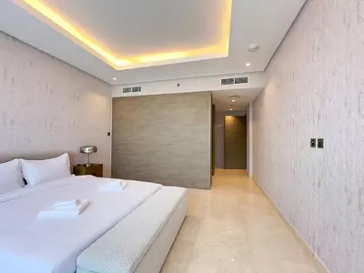 a bedroom with a large white bed and a sliding door at Unique Luxury White 2BR Apartment in Dubai