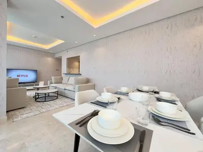 a living room with a table and a couch at Unique Luxury White 2BR Apartment in Dubai