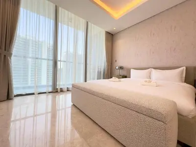 a bedroom with a large bed and large windows at Unique Luxury White 2BR Apartment in Dubai