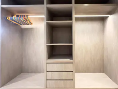 a walk in closet with wooden shelves at Unique Luxury White 2BR Apartment in Dubai