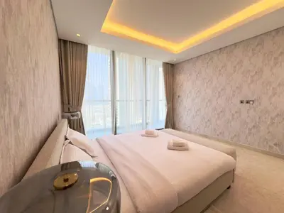 a bedroom with a large bed and a glass table at Contemporary Urban 2BR Apartment in Dubai