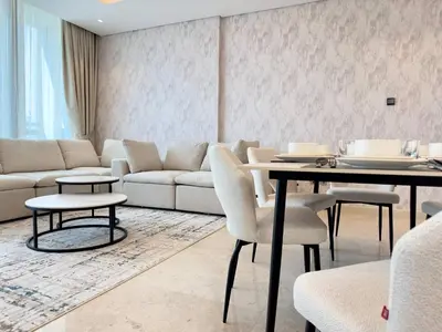 a living room with a couch and a table and chairs at Contemporary Urban 2BR Apartment in Dubai