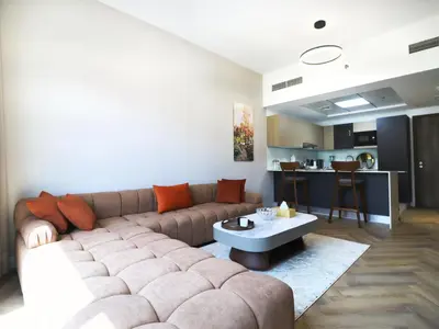 a living room with a couch and a table at Spacious Designer Home Pool, Gym & Playground in Dubai