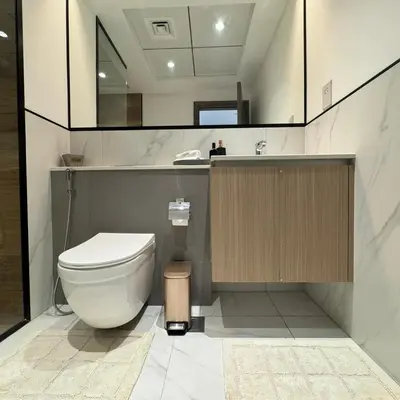 a bathroom with a toilet and a sink and a mirror at Spacious Designer Home Pool, Gym & Playground in Dubai