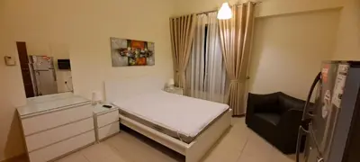 a small bedroom with a bed and a chair at Zaman Vacation Homes in Dubai