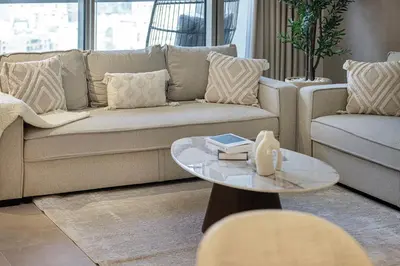 a living room with a couch and a table at 2BR Burj & Fountain View 5 mins to Dubai Mall in Dubai
