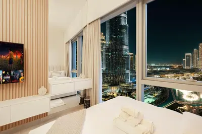 a bedroom with a large window with a city skyline at 2BR Burj & Fountain View 5 mins to Dubai Mall in Dubai