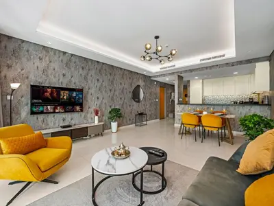 a living room with a yellow couch and a table at Spectacular Burj View from Infinity Pool in Dubai