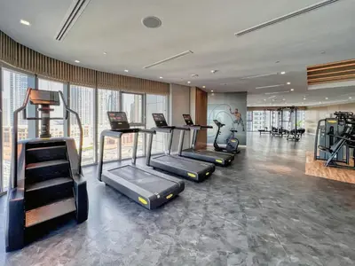 a gym with treadmills and exercise equipment in a room at Spectacular Burj View from Infinity Pool in Dubai