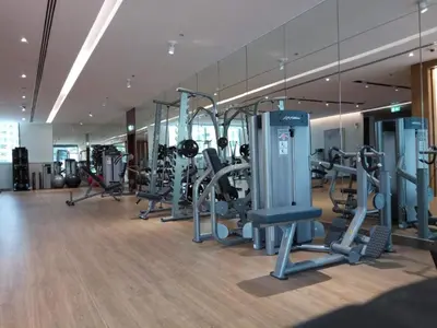 a gym with a row of treadmills and machines at Walk to Metro, Tram & Beach, Stylish 1BR in Marina Pinnacle, Dubai Marina by Deluxe Holiday Homes in Dubai