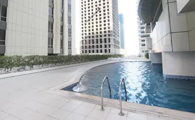 a swimming pool in the middle of a building with tall buildings at Walk to Metro, Tram & Beach, Stylish 1BR in Marina Pinnacle, Dubai Marina by Deluxe Holiday Homes in Dubai