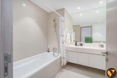 a white bathroom with a tub and a sink at Vogue Downtown Act One near Burj Khalifa and Dubai Mall, Two Bedroom Apartment with Balcony and City Skyline View, Access to All Amenities in Dubai