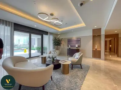 a living room with white chairs and a table at Vogue Downtown Act One near Burj Khalifa and Dubai Mall, Two Bedroom Apartment with Balcony and City Skyline View, Access to All Amenities in Dubai