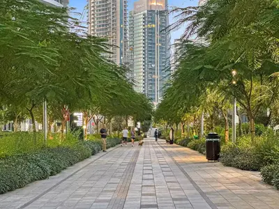 a walkway in a city with trees and buildings at Vogue Downtown Act One near Burj Khalifa and Dubai Mall, Two Bedroom Apartment with Balcony and City Skyline View, Access to All Amenities in Dubai