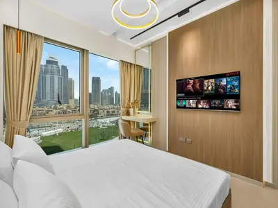 a hotel room with a bed and a large window at Grande Signature Residence 907 Full Burj Khalifa and Dubai Dancing Fountain View 5 Min Walk Dubai Mall Luxury Downtown Apartment in Dubai