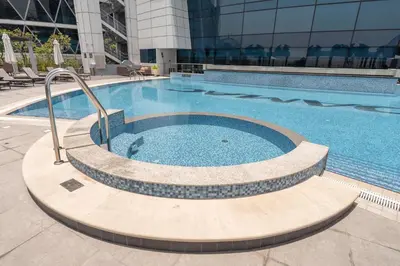 a large swimming pool in a building at StayShort - Stylish DIFC Apartment Sleeps 4 with Pool & Gym in Dubai