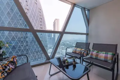 a room with two chairs and a table in front of windows at StayShort - Stylish DIFC Apartment Sleeps 4 with Pool & Gym in Dubai