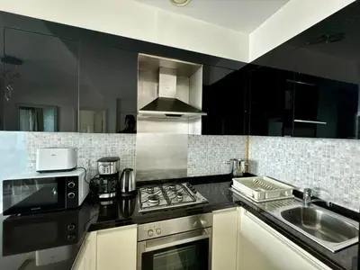 a kitchen with a stove top oven next to a sink at Damac Maison Mall Street,Burj Khalifa in Dubai