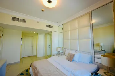 a bedroom with a large bed with a large headboard at Damac Maison Mall Street,Burj Khalifa in Dubai