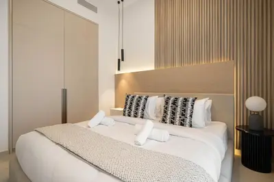 a bedroom with a large white bed with white pillows at Elegant 2BR Apartment near Burj Khalifa, Downtown Dubai in Dubai