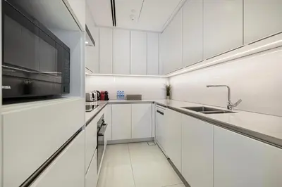 a white kitchen with white cabinets and a sink at Address JBR, 57th Floor Luxury Marina Beach View in Dubai