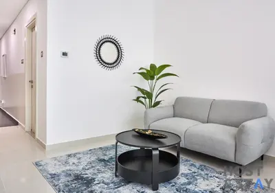 a living room with a couch and a table at Bright Studio in Loreto DAMAC Hills - Pet-Friendly in Dubai