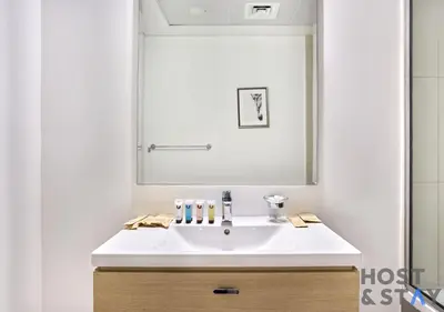 a bathroom with a white sink and a mirror at Bright Studio in Loreto DAMAC Hills - Pet-Friendly in Dubai