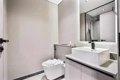 a white bathroom with a toilet and a sink at PVH - Serene Studio minutes to Downtown - MAG Eye in Dubai