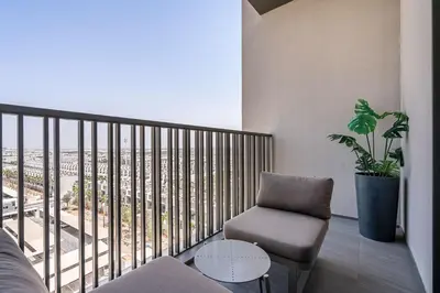 a living room with a chair and a balcony at PVH - Serene Studio minutes to Downtown - MAG Eye in Dubai