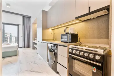a kitchen with a stove and a microwave at PVH - Serene Studio minutes to Downtown - MAG Eye in Dubai