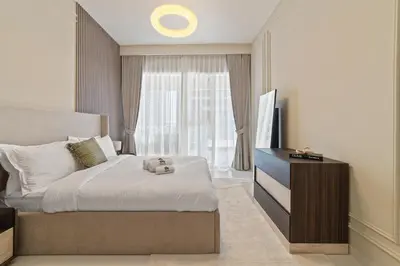 a bedroom with a bed and a dresser and a window at Werova - Luxury 2-Bedroom Apartment with Sea View in Dubai