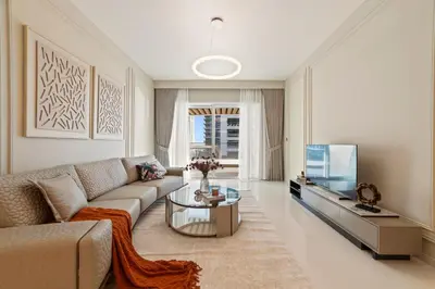 a living room with a couch and a table and a tv at Werova - Luxury 2-Bedroom Apartment with Sea View in Dubai