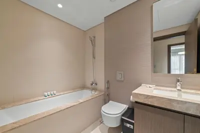 a bathroom with a tub and a toilet and a sink at Werova - Luxury 2-Bedroom Apartment with Sea View in Dubai