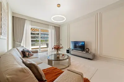a living room with a couch and a tv at Werova - Luxury 2-Bedroom Apartment with Sea View in Dubai