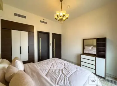 a bedroom with a bed and a mirror and a chandelier at Huge luxurious 1 bedroom in Dubai