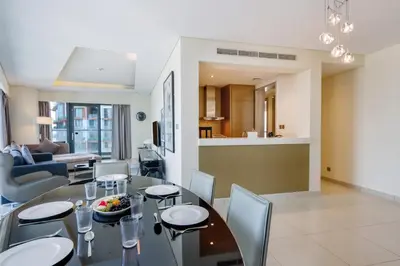 a dining room and living room with a table and chairs at Stylish 2BR Paramount Apt Near Downtown in Dubai