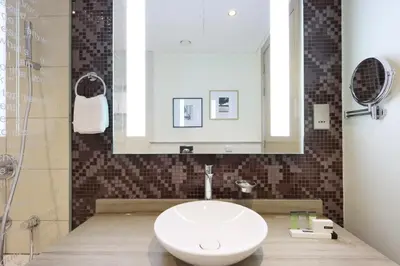 a bathroom with a white sink and a mirror at Stylish 2BR Paramount Apt Near Downtown in Dubai