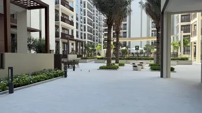 a courtyard in a building with palm trees and tables at Waterfront View, Boutique apartment, Lagoon Access in Dubai