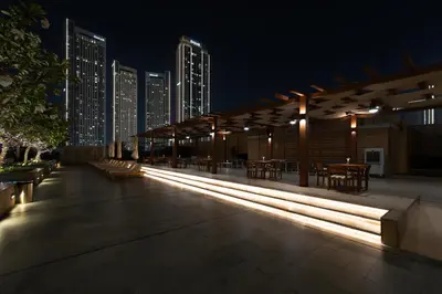 a building with benches and tables at night at Panoramic Burj Khalifa Views - Modern & Comfy Gem in Dubai
