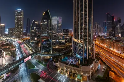 a city lit up at night with traffic at Panoramic Burj Khalifa Views - Modern & Comfy Gem in Dubai