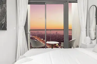 a bedroom with a view of a city at Cozy Sunset Retreat - Burj, Palm & Sea View - 2 BR in Dubai