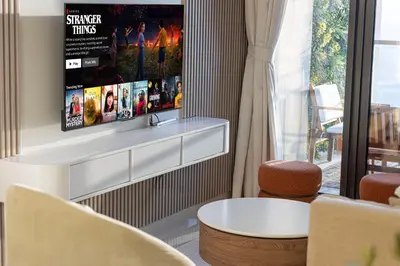 a living room with a tv on a wall at Cozy Sunset Retreat - Burj, Palm & Sea View - 2 BR in Dubai