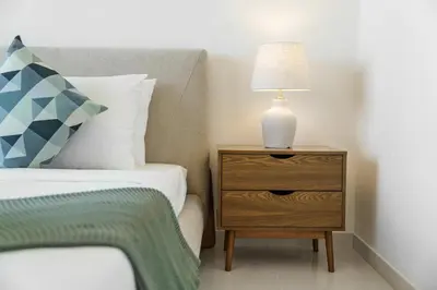 a bedroom with a bed and a nightstand with a lamp at Elegant 2BR in Beachfront with Stunning Marina Views in Dubai